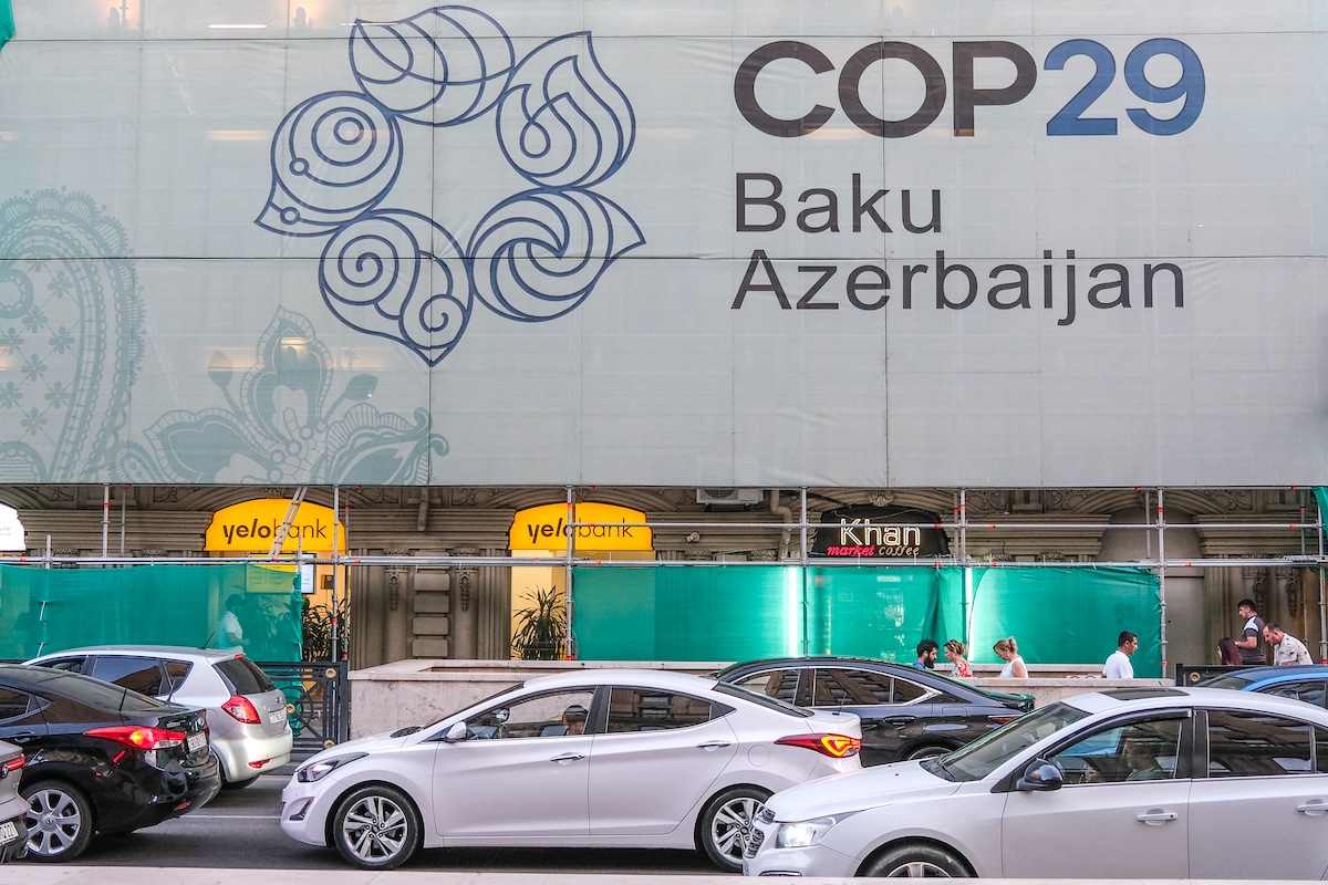 Cars pass by a sign for the 2024 UN Climate Change Conference (UNFCCC COP 29) which will convene in Baku, Azerbaijan in November